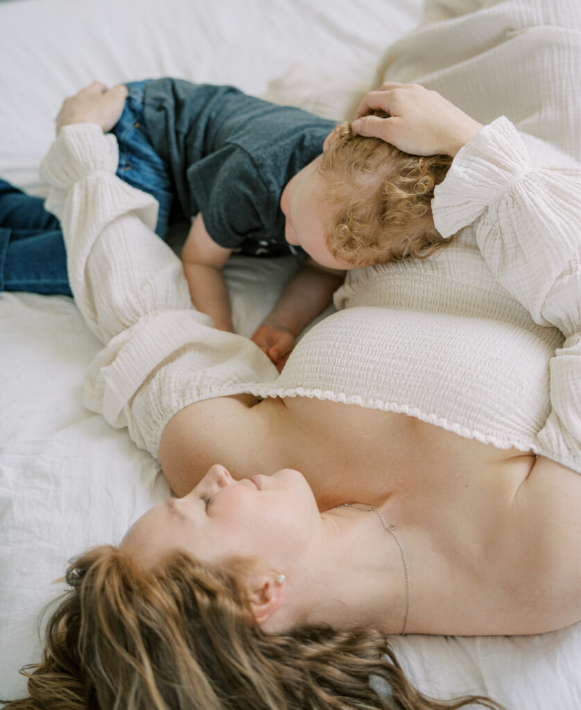 pregnant woman snuggling son 